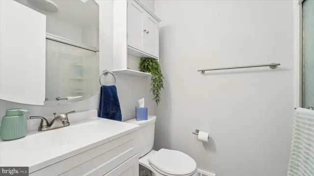 a bathroom with a sink vanity mirror and toilet
