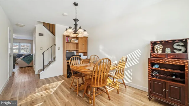 a dining room with furniture wooden floor a rug and a chandelier
