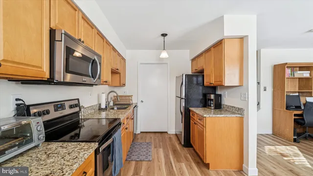 a kitchen with stainless steel appliances granite countertop a stove sink microwave and refrigerator