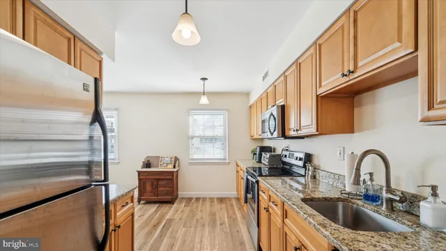 a kitchen with stainless steel appliances a sink a stove and cabinets