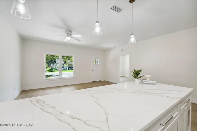 a large kitchen with granite countertop a stove top oven a sink a counter space and cabinets