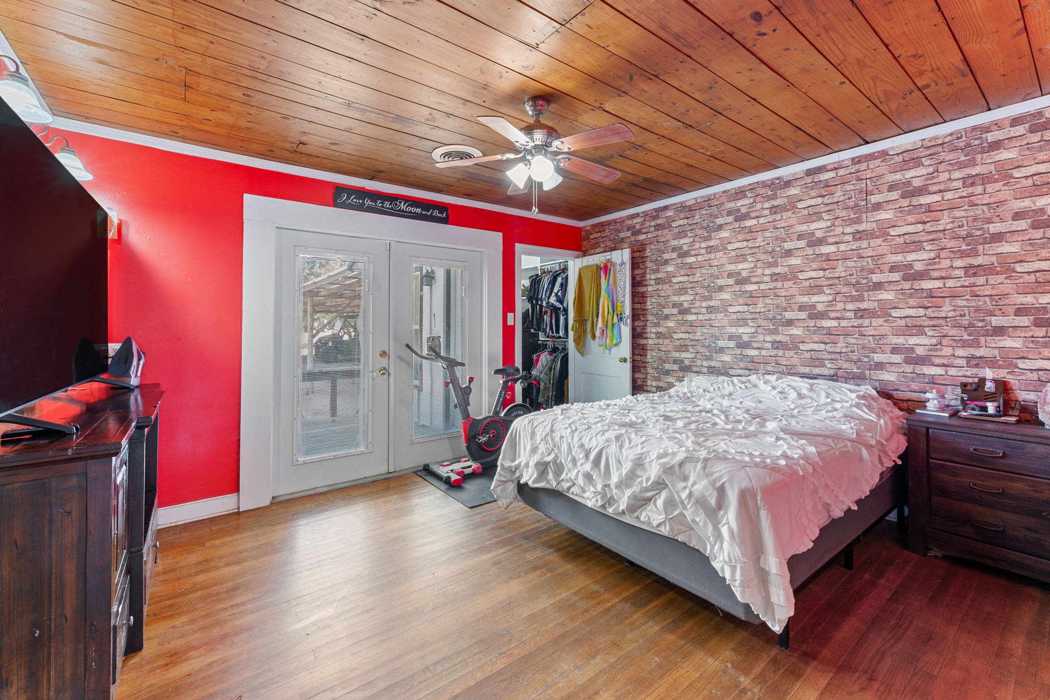 274 Old Potato Road Paige, TX 78659 - Photo 11 of 39 Bedroom with french doors, wood finished floors, brick wall, crown molding, and access to exterior
