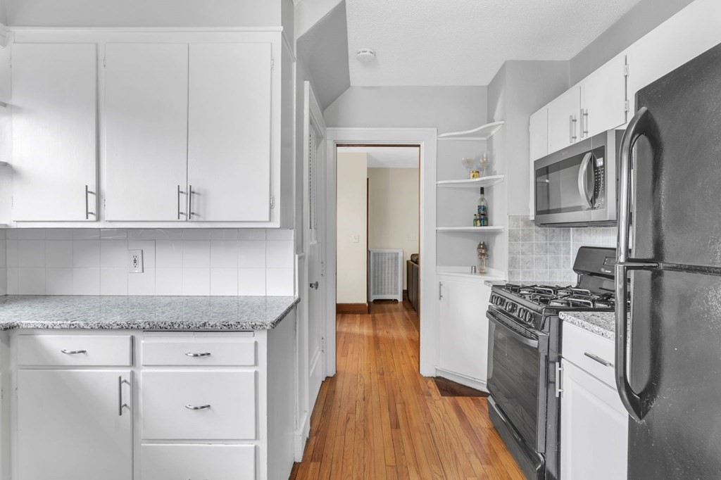 108 Manchester Terrace Springfield, MA 01108 - Photo 22 of 40 a kitchen with stainless steel appliances granite countertop a refrigerator stove and white cabinets