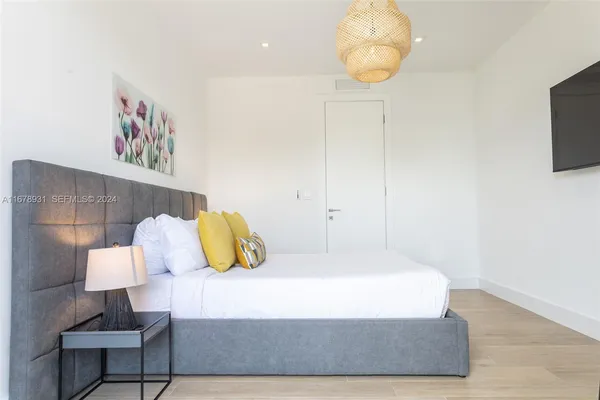 a bedroom with a bed and painting on the wall