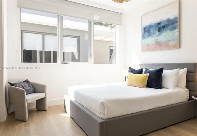 a bedroom with a bed and a large window