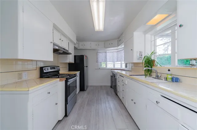 a kitchen with granite countertop a sink stainless steel appliances a counter space and cabinets