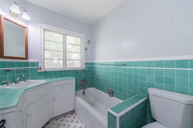 a bathroom with a sink mirror toilet and bathtub