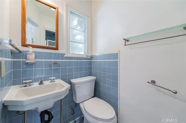 a bathroom with a sink a toilet and a mirror