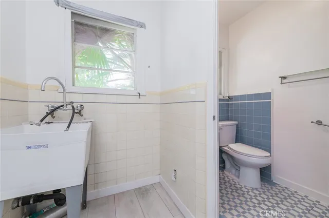 a bathroom with a sink a toilet and a window