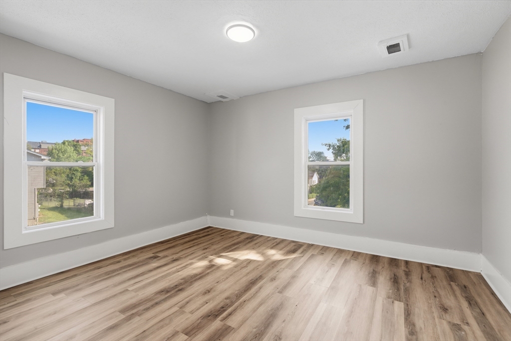 834 Worthington Street, Unit 2 Springfield, MA 01105 - Photo 11 of 20 a view of an empty room with wooden floor and a window