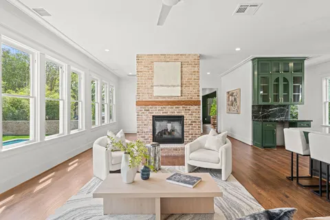 a living room with fireplace furniture and a large window