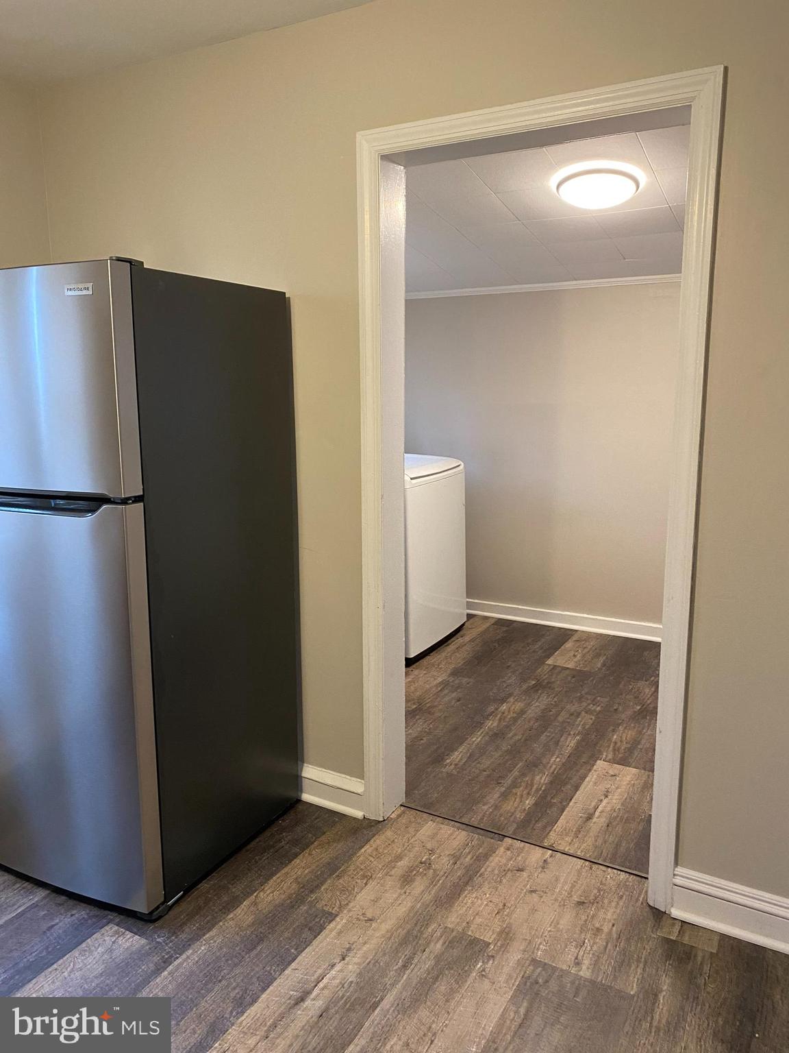 258 Birch Street Penns Grove, NJ 08069 - Photo 18 of 41 a view of a refrigerator in kitchen and an empty room with wooden floor