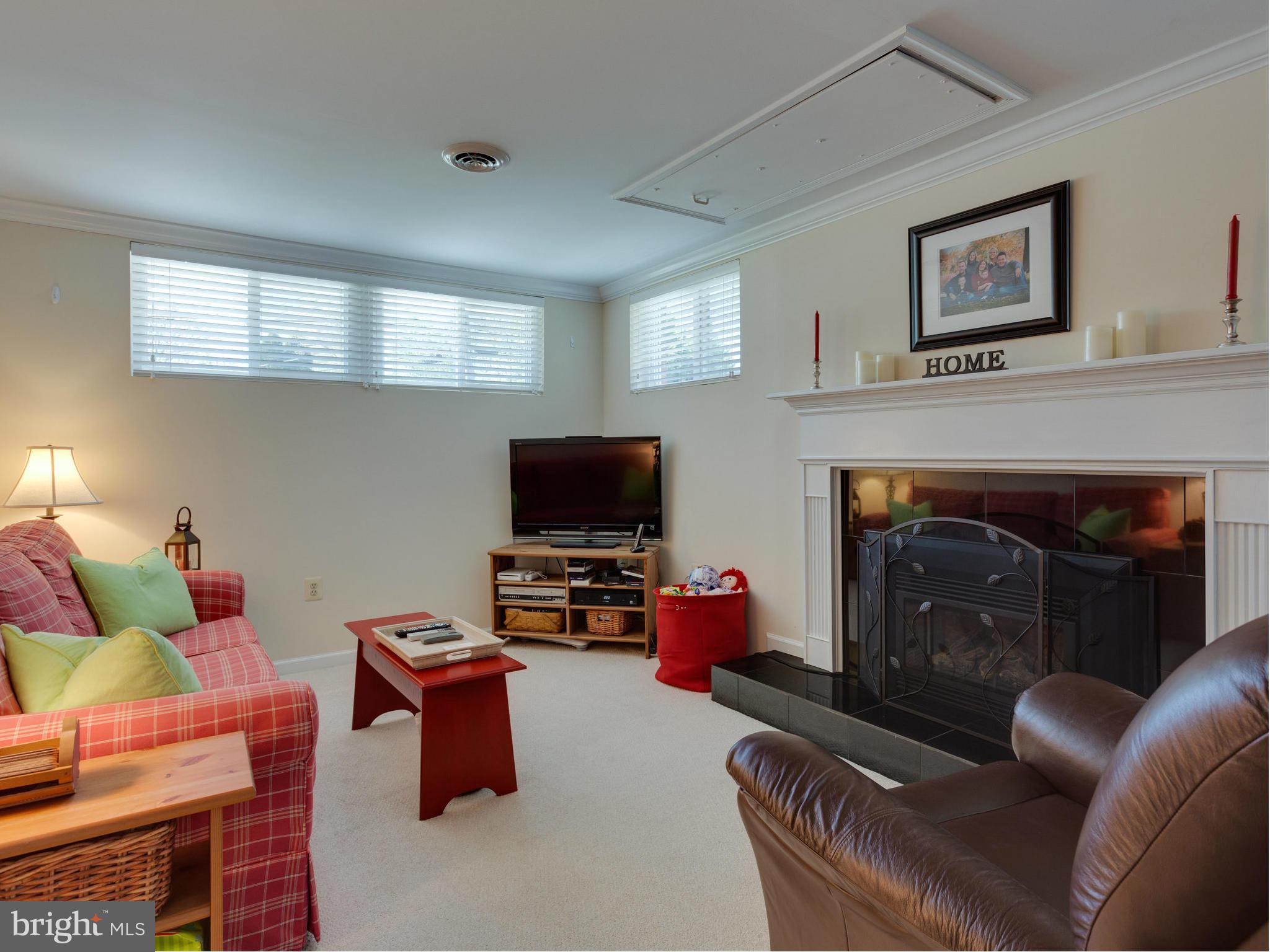 5218 Garner Street Springfield, VA 22151 - Photo 19 of 29 a living room with furniture a flat screen tv and a fireplace