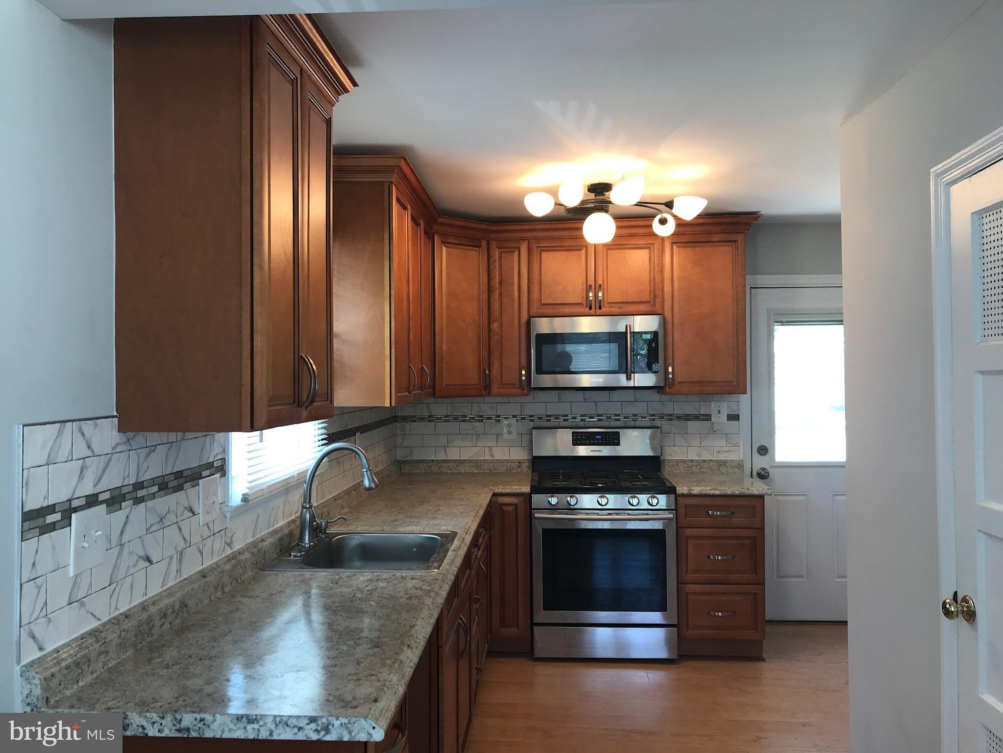 3134 Dashiell Road Falls Church, VA 22042 - Photo 4 of 10 a kitchen with stainless steel appliances granite countertop a stove a sink and a microwave