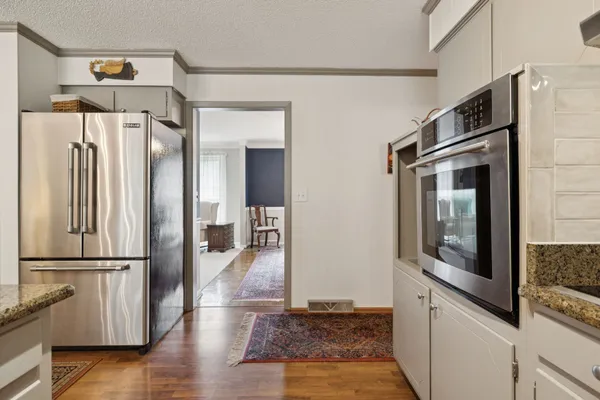 a kitchen with stainless steel appliances granite countertop a refrigerator and a stove top oven