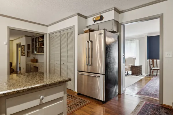 a kitchen with granite countertop a refrigerator and a counter top space