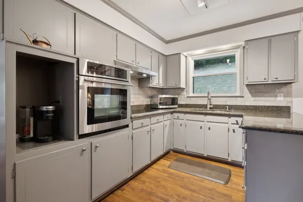 a kitchen with stainless steel appliances granite countertop a sink a stove and cabinets