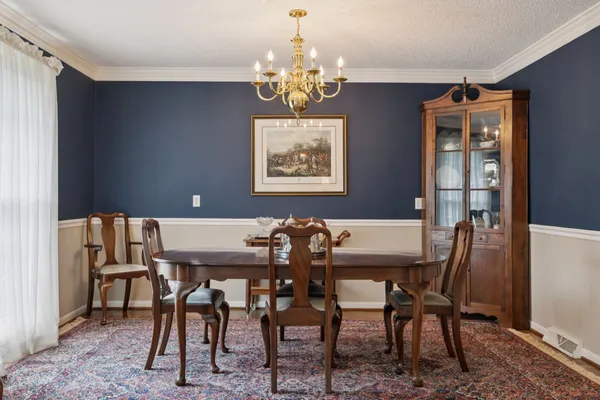 a view of a dining room with furniture and chandelier