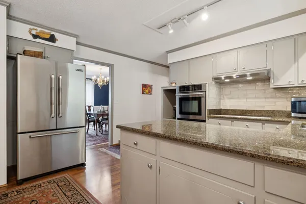 a kitchen with granite countertop a refrigerator and a sink