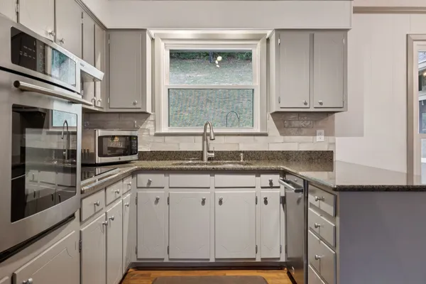 a kitchen with stainless steel appliances granite countertop a sink and cabinets