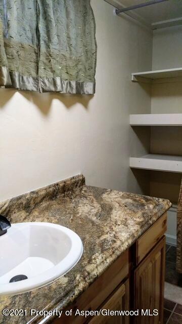 207 Ash Avenue Rifle, CO 81650 - Photo 15 of 21 a bathroom with a granite countertop sink and a mirror
