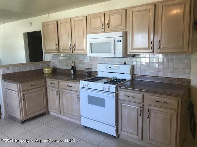 207 Ash Avenue Rifle, CO 81650 - Photo 4 of 21 a kitchen with stainless steel appliances granite countertop a sink stove and microwave
