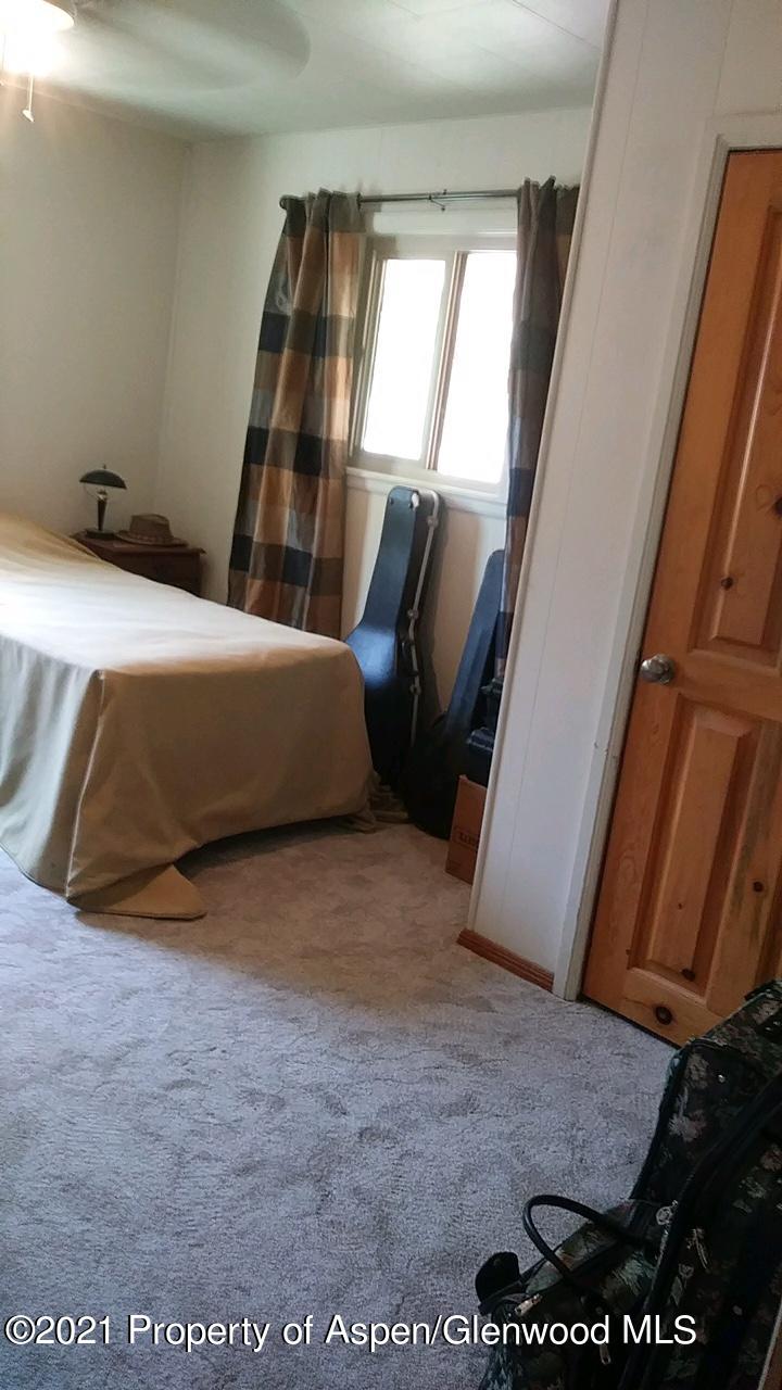 207 Ash Avenue Rifle, CO 81650 - Photo 9 of 21 a bed sitting in a room next to a window