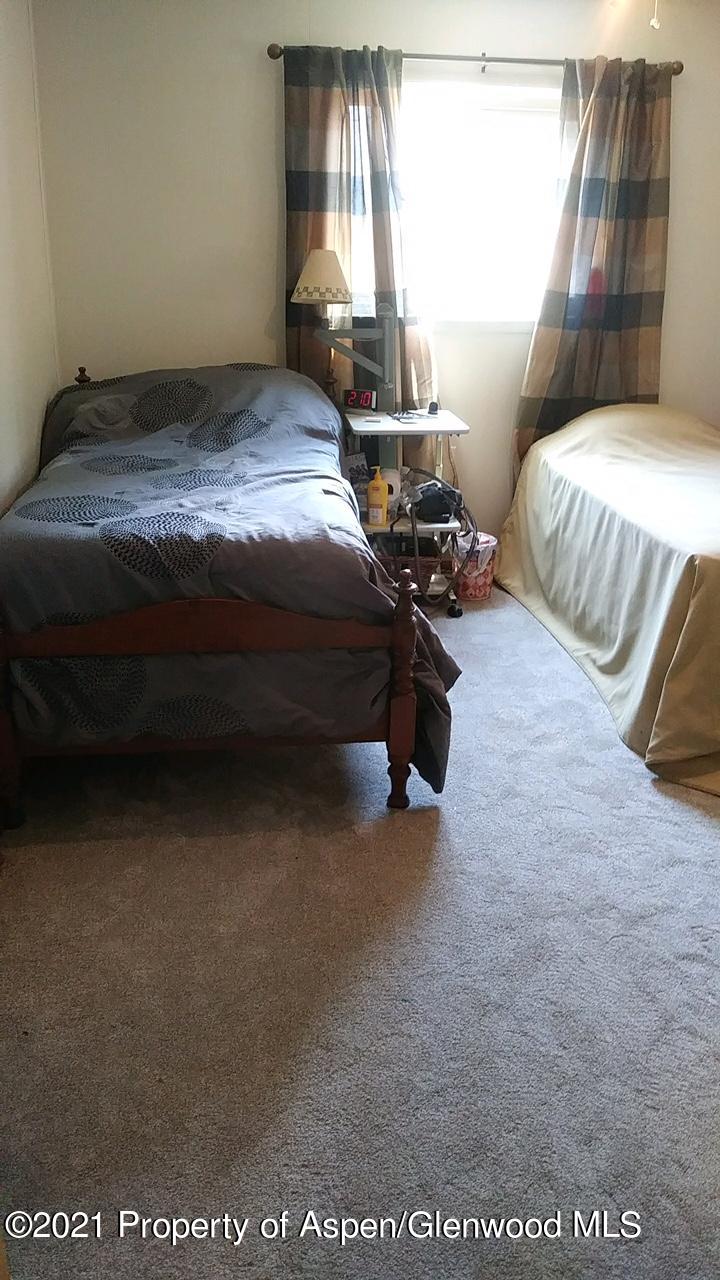207 Ash Avenue Rifle, CO 81650 - Photo 10 of 21 a bed sitting in a bedroom next to a window