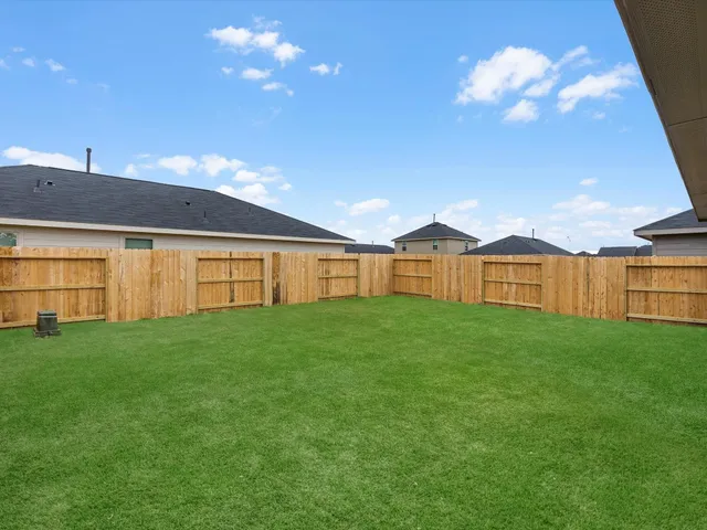 a view of a big house with a big yard and large trees