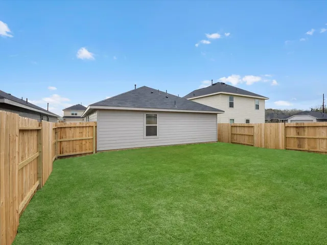 a view of a backyard with wooden fence
