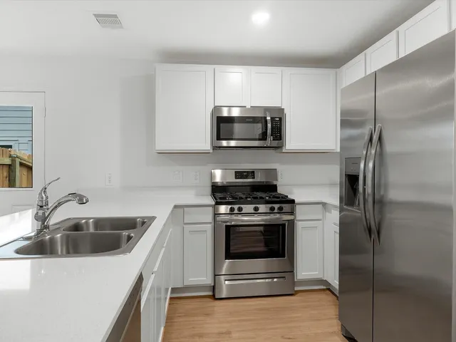 a kitchen with a sink stove and refrigerator