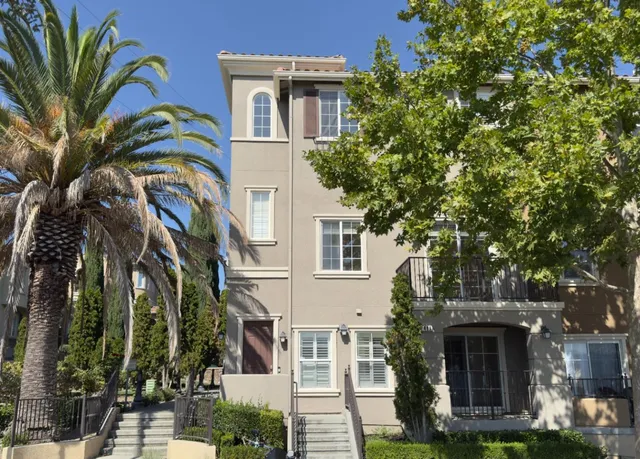 a front view of a house with a tree