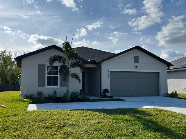 a front view of house with yard and garage