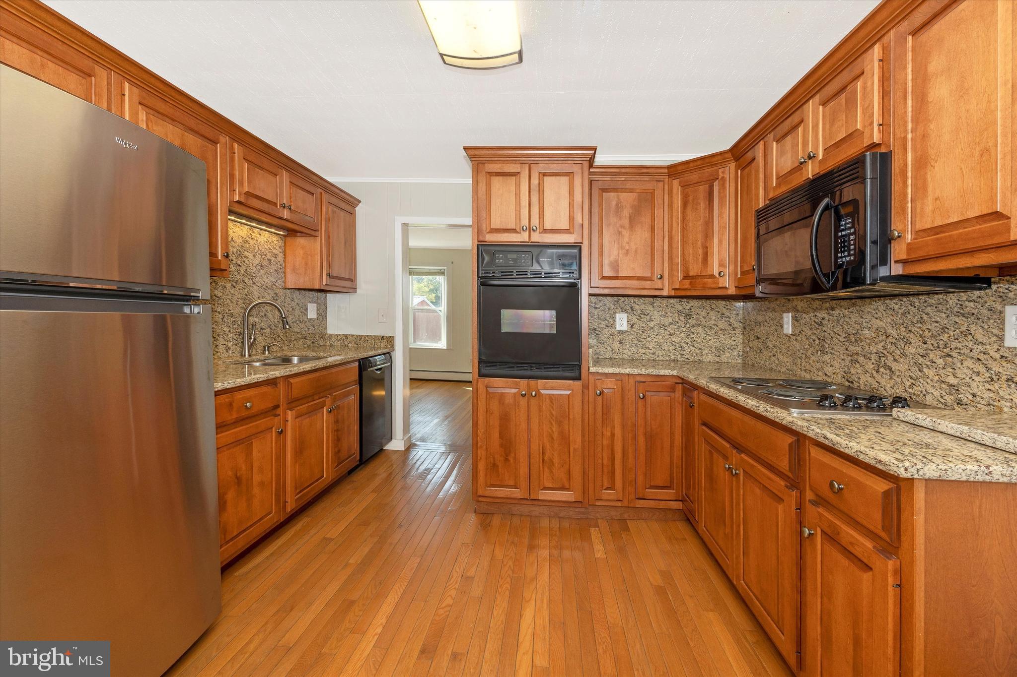 1021 Saffell Road Reisterstown, MD 21136 - Photo 40 of 57 a kitchen with stainless steel appliances granite countertop a refrigerator a stove top oven and sink