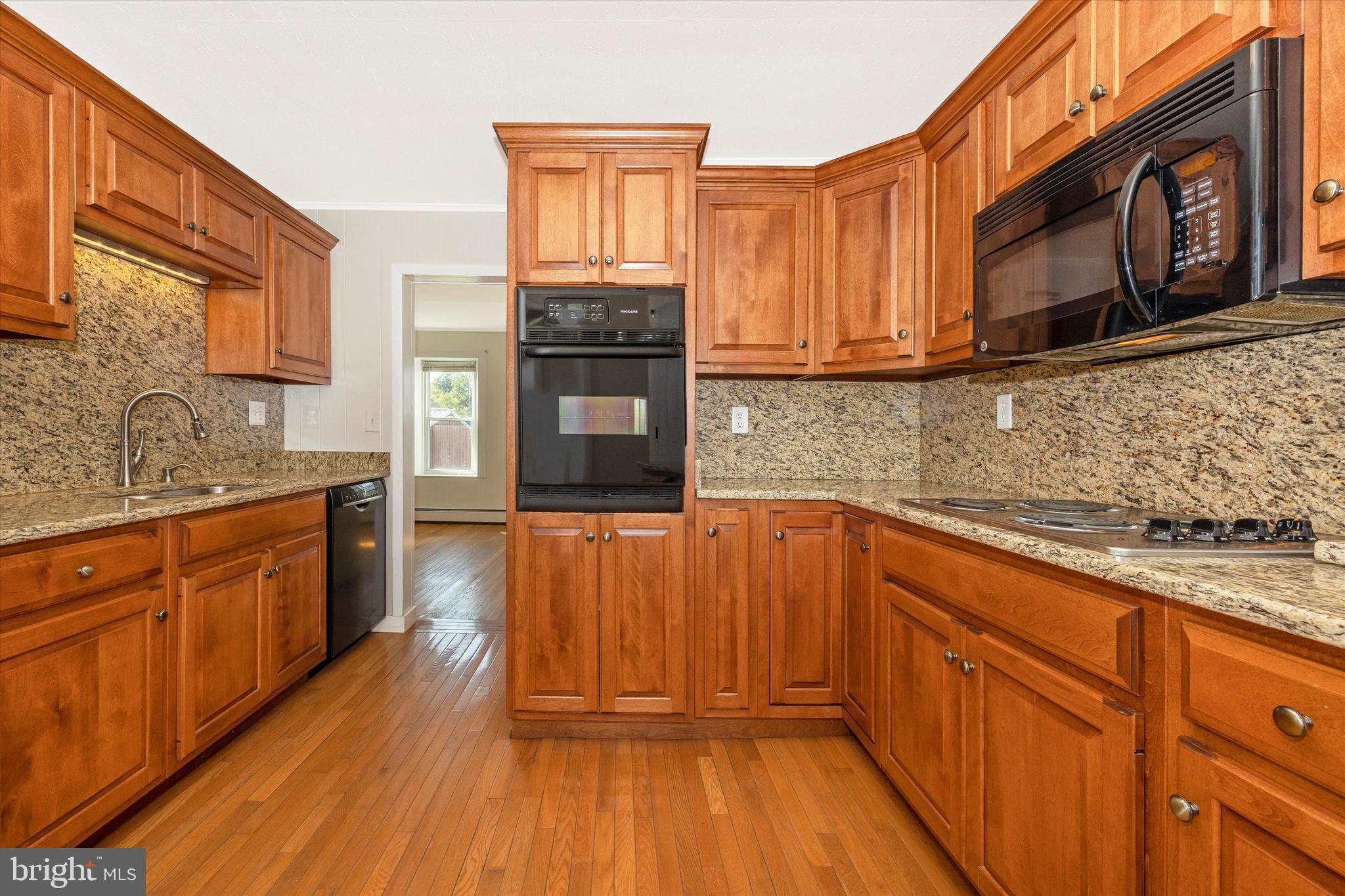 1021 Saffell Road Reisterstown, MD 21136 - Photo 41 of 57 a kitchen with wooden floors wooden cabinets and appliances