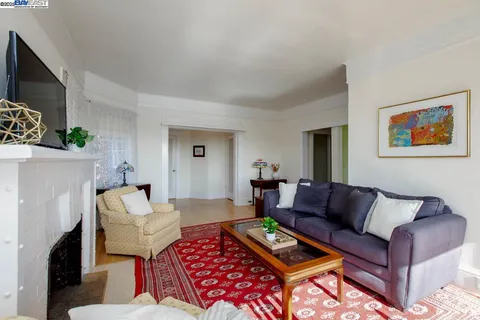 a living room with furniture a rug a fireplace and a large window