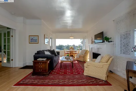 a view of a livingroom with furniture a fireplace a rug and a chandelier