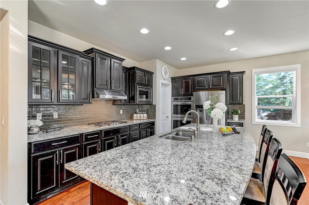3228 170th Place Southeast Bothell, WA 98012 - Photo 6 of 40 a kitchen with stainless steel appliances granite countertop sink stove top oven and microwave