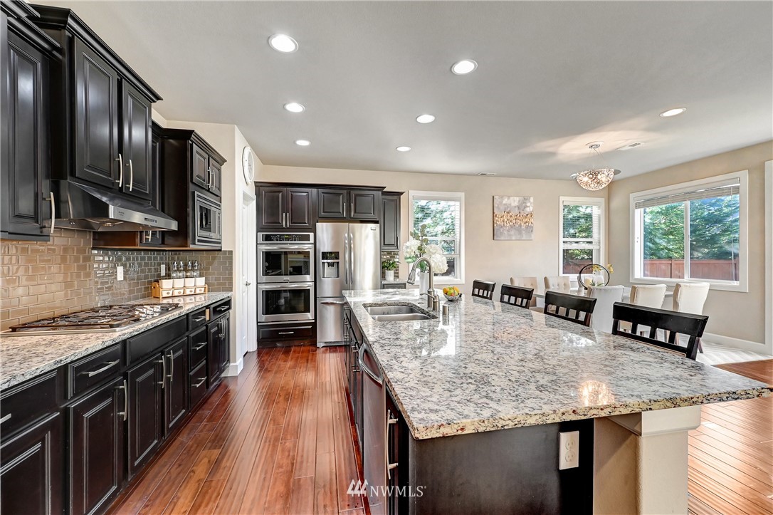 3228 170th Place Southeast Bothell, WA 98012 - Photo 7 of 40 a kitchen with stainless steel appliances granite countertop a stove refrigerator and cabinets