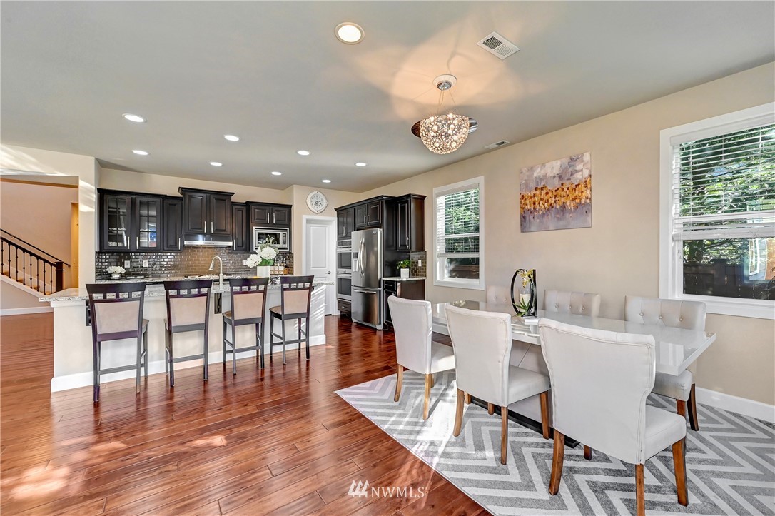3228 170th Place Southeast Bothell, WA 98012 - Photo 8 of 40 a view of a dining room with furniture and wooden floor