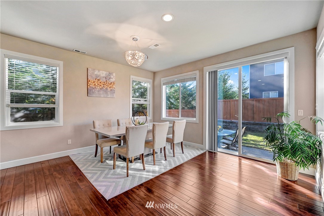 3228 170th Place Southeast Bothell, WA 98012 - Photo 9 of 40 a dining room with wooden floor a glass table and chairs