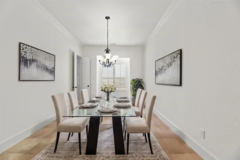 a view of a dining room with furniture a chandelier and wooden floor