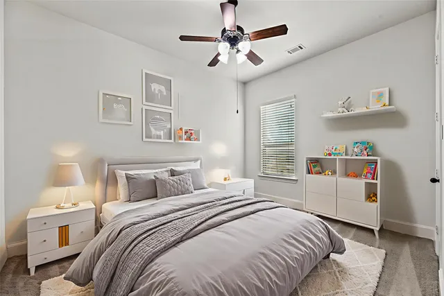a bedroom with a white bed and white cabinets