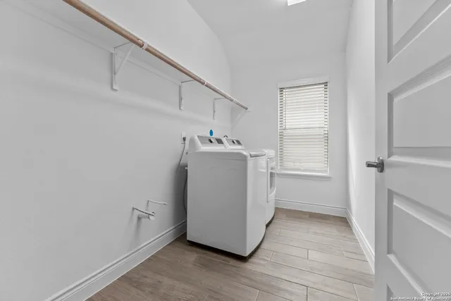 a utility room with wooden floor washer and dryer
