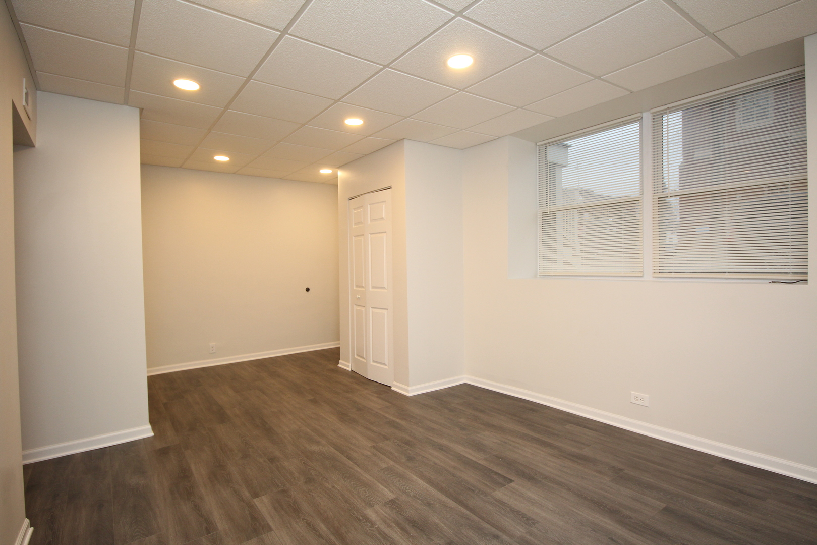 120 North Spring Street, Unit 1 Elgin, IL 60120 - Photo 7 of 12 an empty room with wooden floor and windows