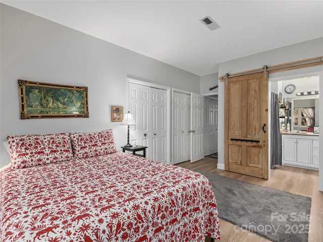 a bedroom with a large bed and wooden floor