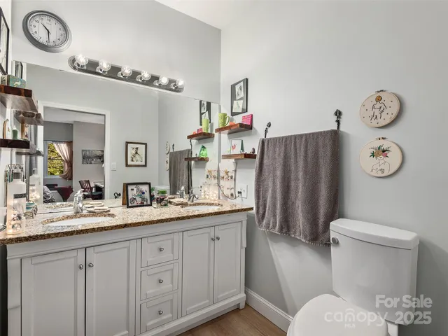 a bathroom with a granite countertop toilet sink and mirror
