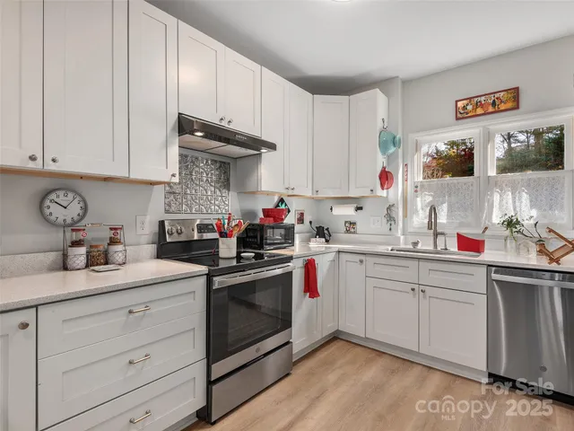 a kitchen with granite countertop white cabinets and white appliances