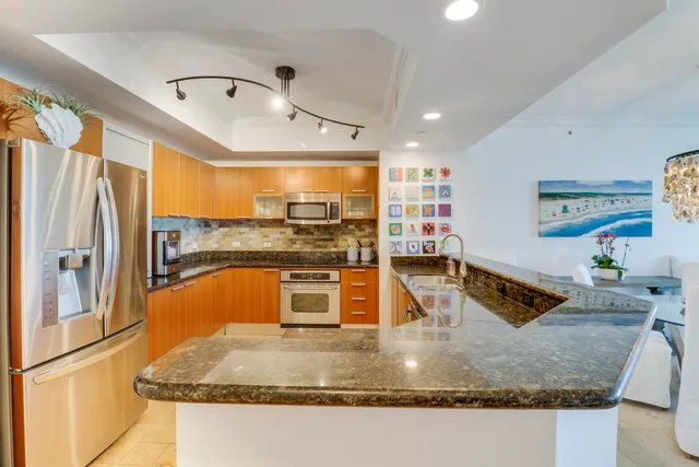 a kitchen with stainless steel appliances granite countertop a sink stove and refrigerator