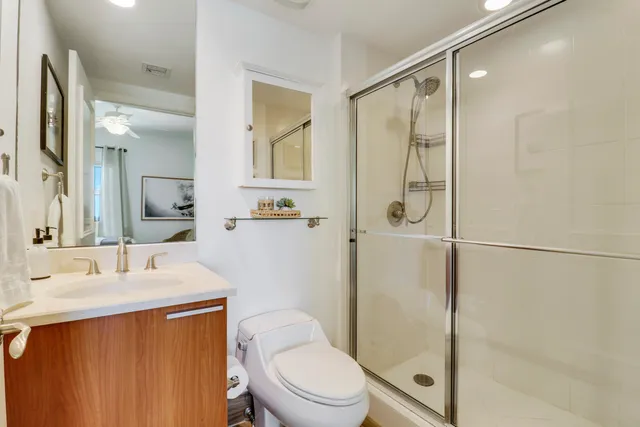 a bathroom with a granite countertop sink toilet and shower